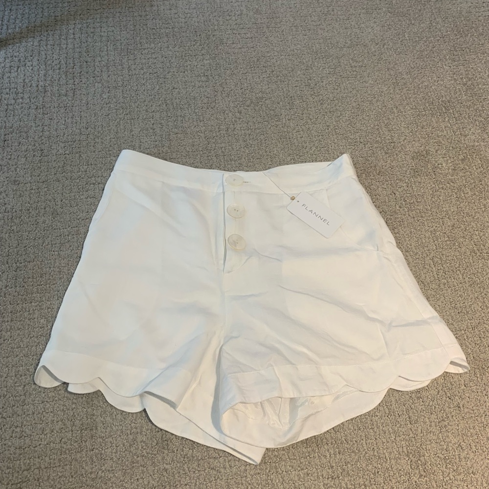 Flannel brand white linen shorts with embroidered detailing on back pockets